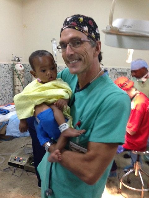 Photo of Dr. Politis with one of our young patients before he had his cleft lip repaired