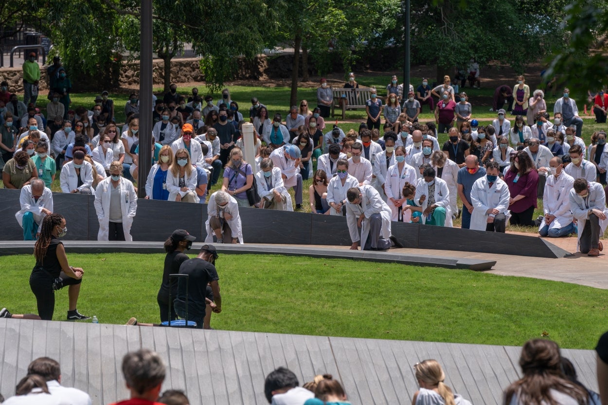 University of Virginia Medical Professionals take a knee at the Memorial to Enslaved Laborers in honor of 8-11 