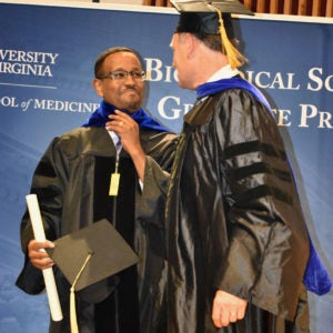 Student smiling as he receives diploma