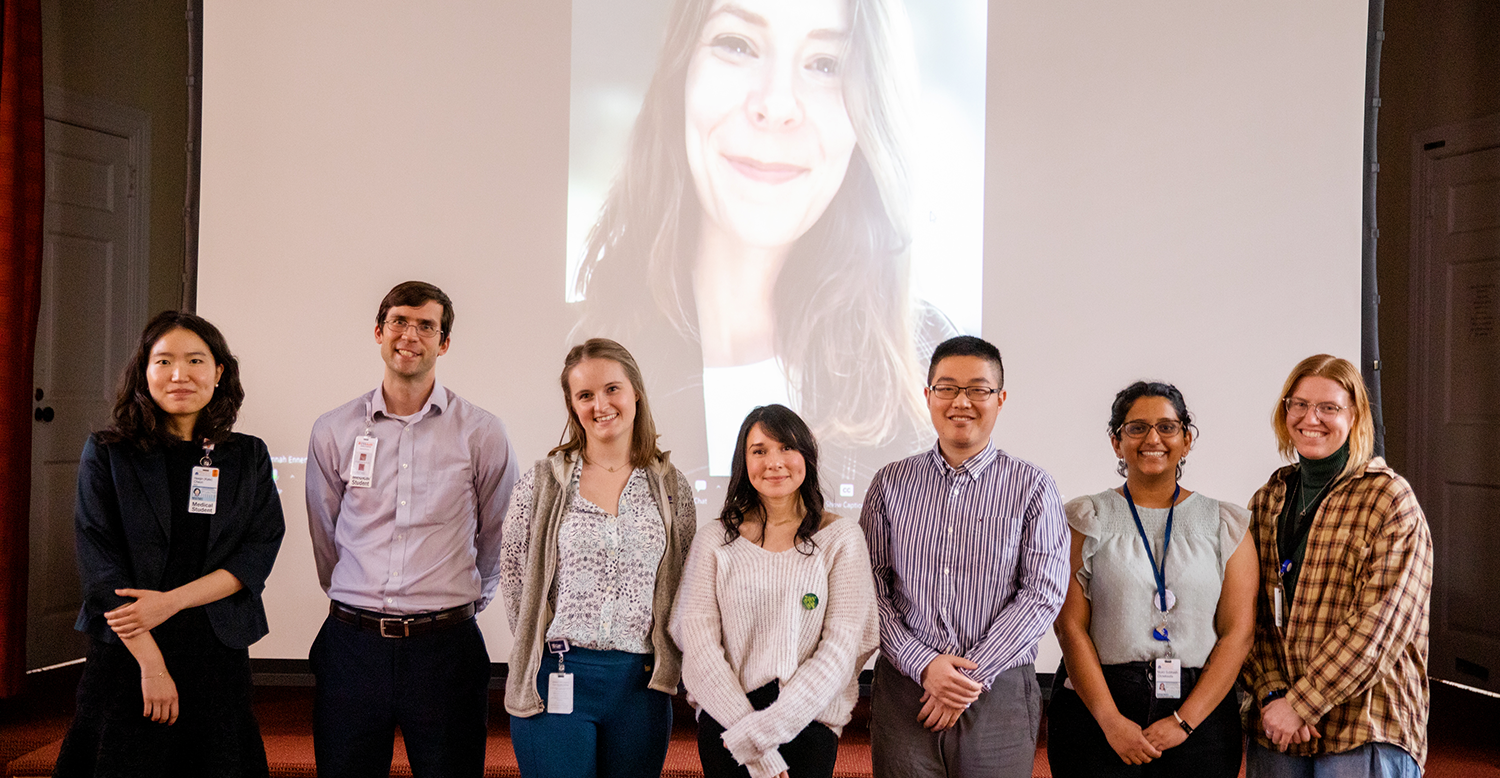 Outstanding student awardees for each PhD program standing together in front of projection screen on stage.