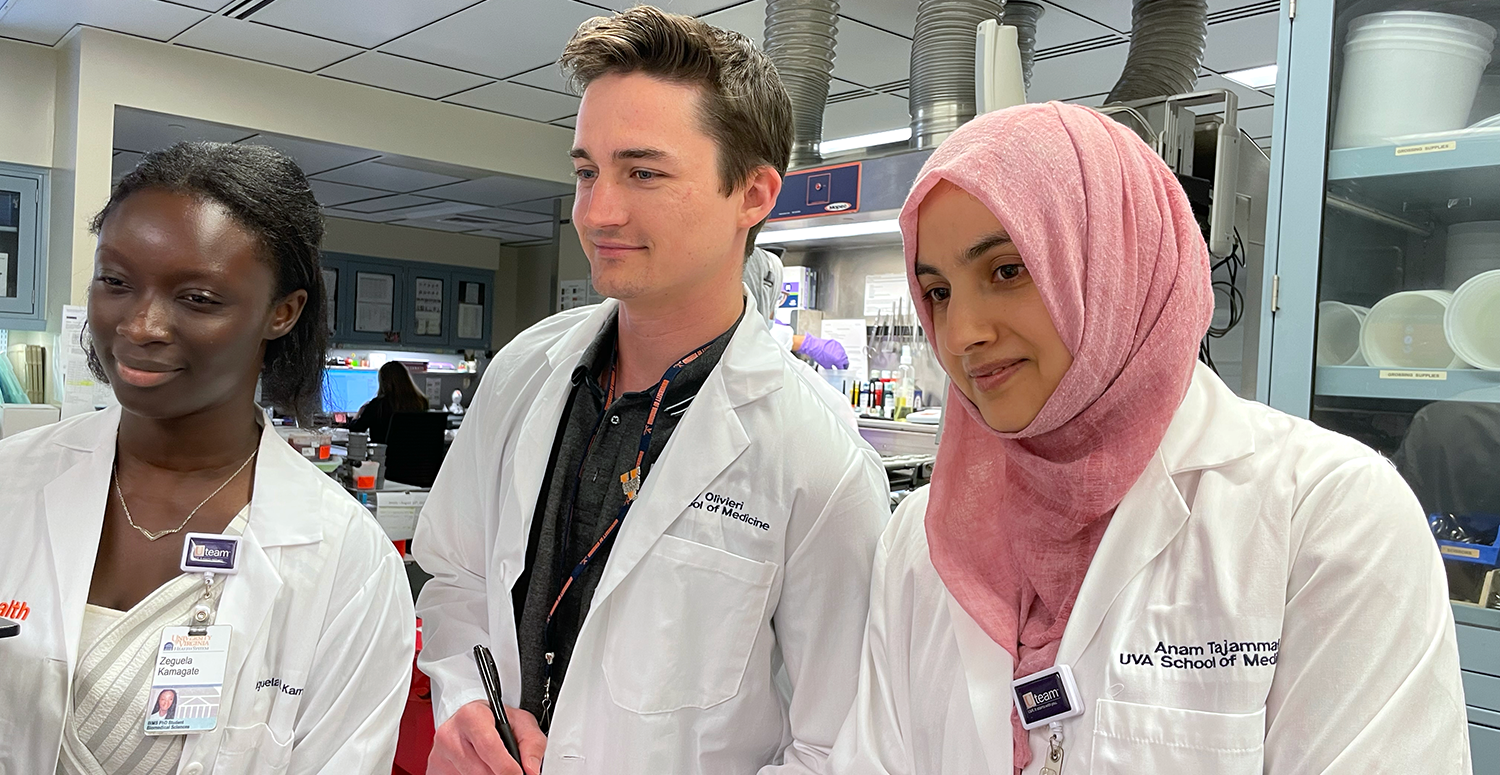 three students standing and smiling in clinical pathology lab for rotation practical experience