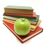 A pile of textbooks and an apple.