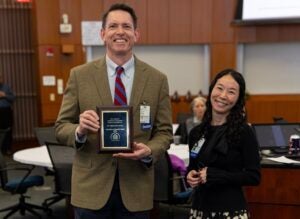 Two people standing accepting an award