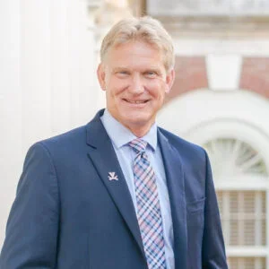 Headshot of a man in blue jacket and tie