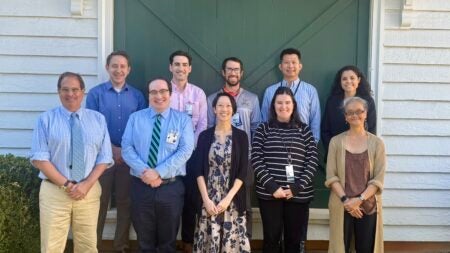A group of people standing in front of a green door