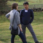 two people talking and standing in a field