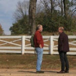 two men standing on a road talking
