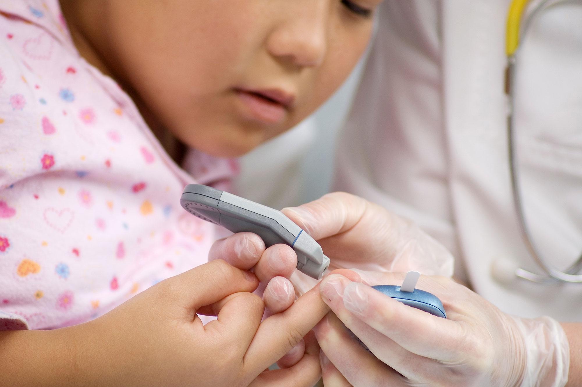 Child receiving a finger prick blood test 