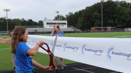 Child cutting a walk ribbon