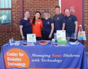 Team members from the center for diabetes technology standing behind a sponsor table.