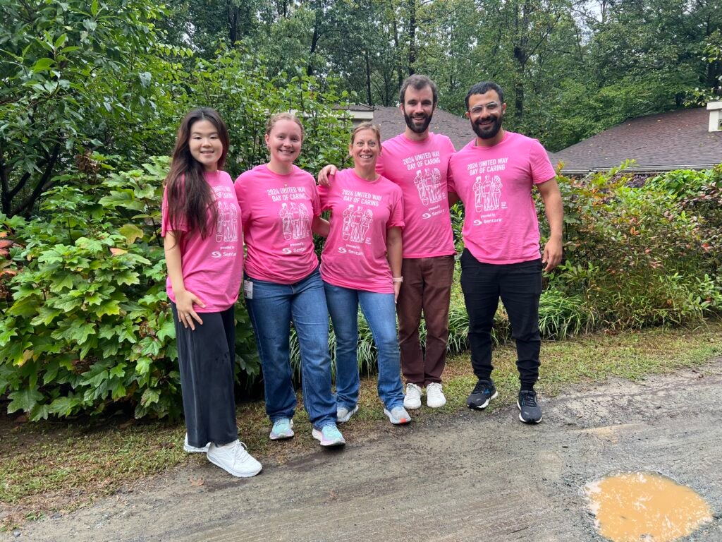 Group photo of 5 people standing together as a team