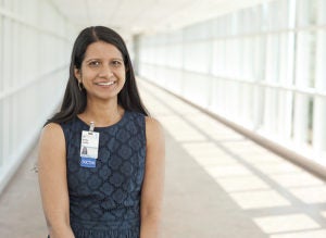 Dr. Sudhir smiling and standing in sunlit hallway