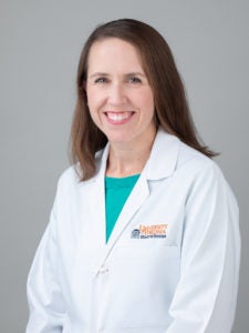 portrait of doctor Margaret Sande smiling and wearing her white lab coat