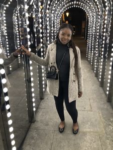 Akinlade standing in a tunnel of lights