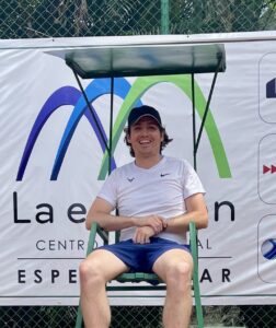 Thomas Bartenstein smiling while sitting in a tall metal green chair