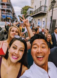 Antony Han and partner smiling together on a busy street