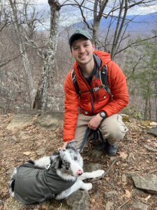 Ethan Smolley outside on a cold weather hike with his dog