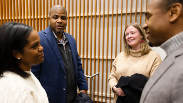 Dr. Leigh-Ann Webb smiling among people congratulating her.