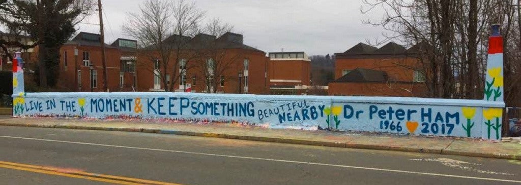 beta bridge, painted with yellow tulips and the words live in the moment and keep something beautiful nearby doctor peter ham 1966 to 2017 with the word to represented as an orange heart