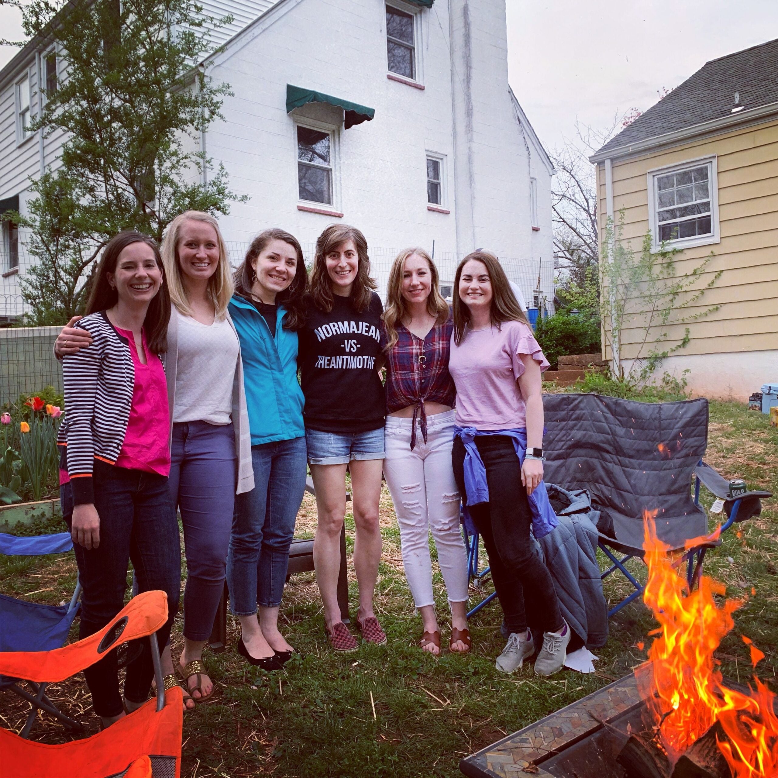 a group of females hanging out by a bon fire