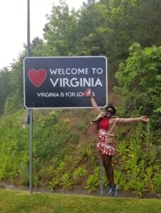 Photo of resident by Welcome to Virginia sign