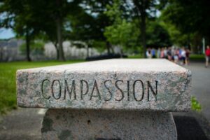 Word "compassion" written on stone bench.