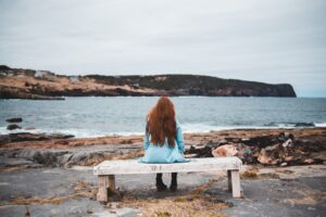 Woman sitting on a stone bench by the sea