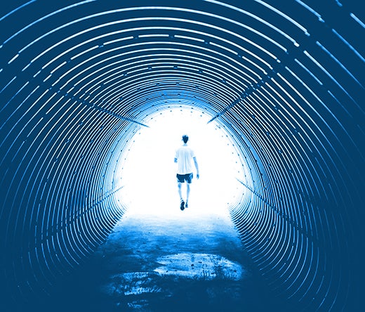 man walking at the end of a tunnel