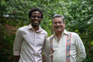 Dr. Eyo and Dr. Perez-Reyes smile in front of greenery