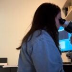 Rachel looks through a microscope