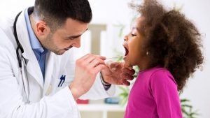 A doctor checking a childs throat