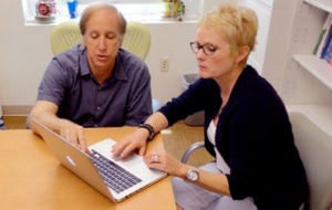 A man and a woman collaborating around a computer