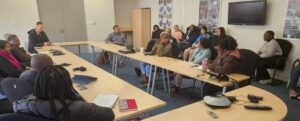 Students and teachers gather around the table to discuss issues.