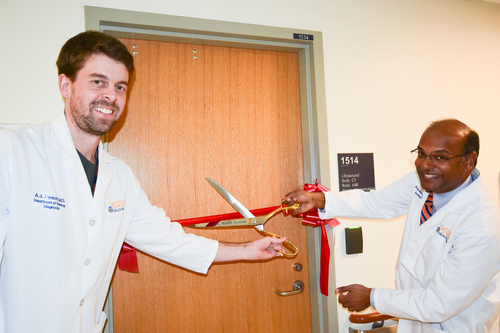 Dr. A.J. Pesch, left, and Dr. Arun Krishnaraj, right, cut the ribbon for the newly-renovated Body Reading Room