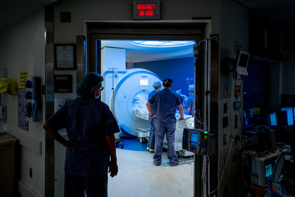 The UVA MRI team positions a patient inside the scanner while a team member watches from outside the room.