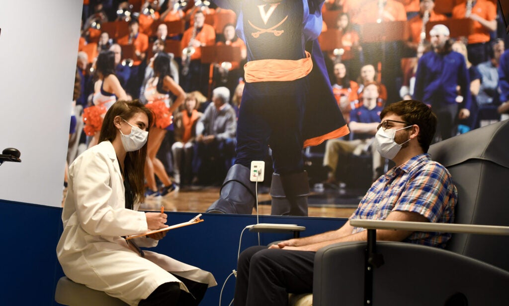 UVA Radiology musculoskeletal fellow speaks with a patient in an exam room at the Orthopedic Outpatient Center