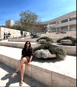 Kanupriya Gupta sitting on stone steps on sunny day
