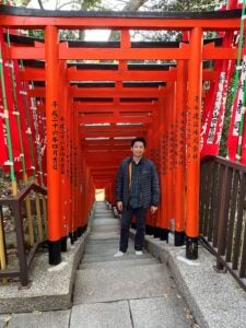 Robert She on footpath underneath orange roofing