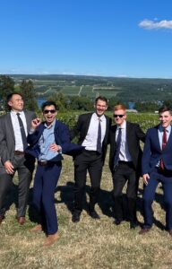 Robert She with friends in suits overlooking mountainside