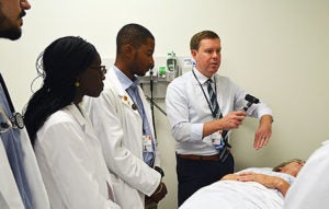 Photo of Dr.Parsons Teaching three residence with real patient