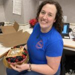 A team member holding a cake for her birthday